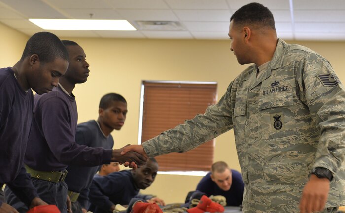 A Three Lakes Valley Boot Camp inmate shakes the hand of Tech. Sgt. Gerald, 799th Security Forces Squadron member, after a mentor session near Creech Air Force Base, Nev., Jan. 13. The boot camp is six months long and if the inmate successfully completes the program they may have their felony reduced to a gross misdemeanor or even expunged. (U.S. Air Force photo by Senior Airman Rachel Loftis)