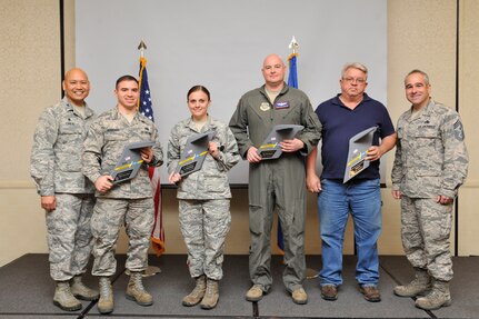 Col. Jimmy Canlas, left, 437th Airlift Wing (AW) commander, and Chief Master Sgt. Kristopher Berg, right, 437th AW command chief, congratulate the 437th AW Fourth Quarterly Award winners during a quarterly awards ceremony at the Joint Base Charleston Air Base Club, Jan. 23, 2016.