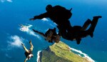 Air Force pararescuemen and West Coast–based Navy SEALs leap from ramp of Air Force C-17 transport aircraft during free-fall parachute training over Marine Corps Base Hawaii, January 2011.