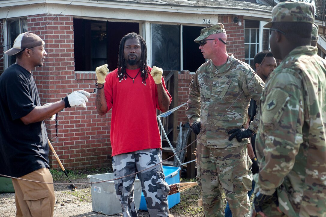 Army Sgt. McGee, center right, and Spc. Baptiste talk to a resident in Hattiesburg, Miss., Jan. 26, 2017, regarding the resident's immediate needs and cleanup procedures after a tornado swept through the area. McGee and Baptiste are assigned to the Mississippi Army National Guard’s 3656th Maintenance Company, 184th Sustainment Command. Army National Guard photo by Staff Sgt. Tim Morgan
