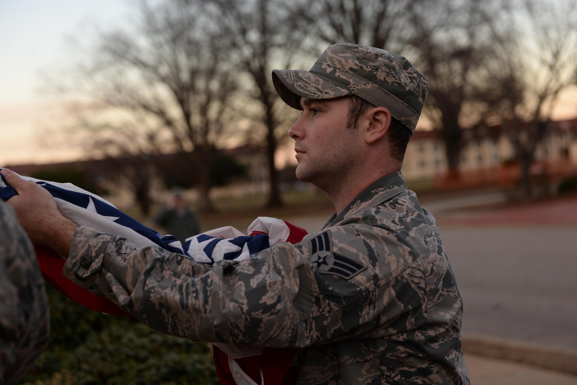 Senior Airman Lloysdstone Jacobs, Airman and Leadership School student, holds the U.S. flag during retreat on Maxwell Air Force Base, Ala., Jan. 26, 2017. All ALS students participate in reveille and retreat every day as part of their duties during the five-week leadership course. (U.S. Air Force photo/Senior Airman Tammie Ramsouer)