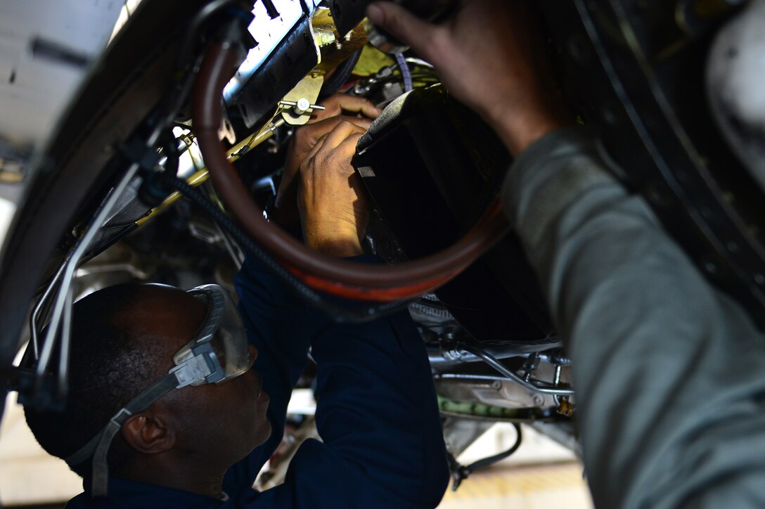 U.S. Air Force Tech. Sgt. Isaiah English, 20th Aircraft Maintenance Squadron tactical aircraft maintainer, examines the wiring under an F-16CM Fighting Falcon at Shaw Air Force Base, S.C., Jan. 25, 2017. English examined the wire to ensure that it was within safety regulations and made repairs where needed. (U.S. Air Force photo by Airman 1st Class Christopher Maldonado)