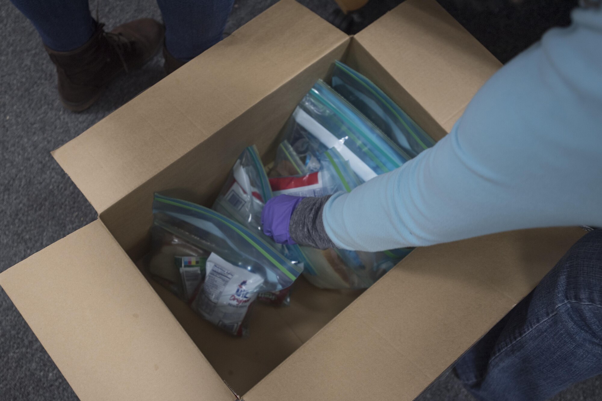 Master Sgt. Denise Edwards, Air Force District of Washington Headquarters functional manager, places bagged lunches in a box at Joint Base Andrews, Md., for a community drive in recognition of Martin Luther King Jr. Day, Jan. 25, 2017. Volunteers assembled approximately 300 bagged lunches and 100 hygiene kits to hand out to community members in need at the Community for Creative Non-Violence in Washington, D.C.