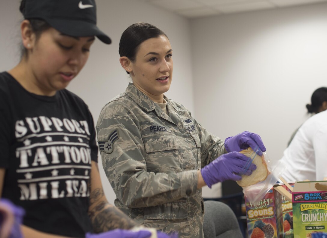 Senior Airm Bernadette Galindo, left, 11th Security Forces Squadron elite gate guard, and Senior Airman Emily Pearce, right, 11th Security Support Squadron unit scheduler, prepare sandwiches at Joint Base Andrews, Md., for a community drive in recognition of Martin Luther King Jr. Day, Jan. 25, 2017. Volunteers prepared approximately 300 bagged lunches to hand out to community members in need at the Community for Creative Non-Violence in Washington, D.C.