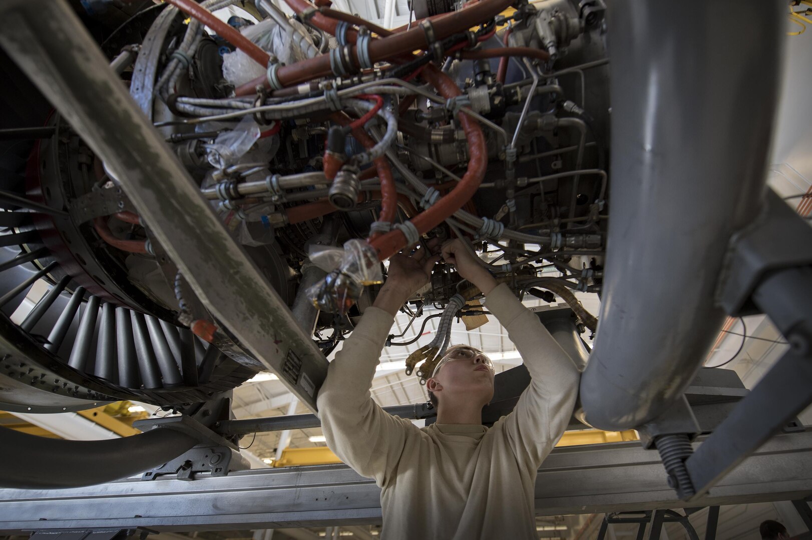Airman 1st Class Anthony Guevara, 23d Component Maintenance Squadron propulsion technician, loosens a connection on the underside of a TF-34 engine used in A-10C Thunderbolt lls, Jan. 25, 2017, at Moody Air Force Base, Ga. Airmen from the propulsion flight are responsible for breaking down, refurbishing and repairing TF-34 engines to replace ones currently in use in A-10s. (U.S. Air Force photo by Airman 1st Class Daniel Snider)
