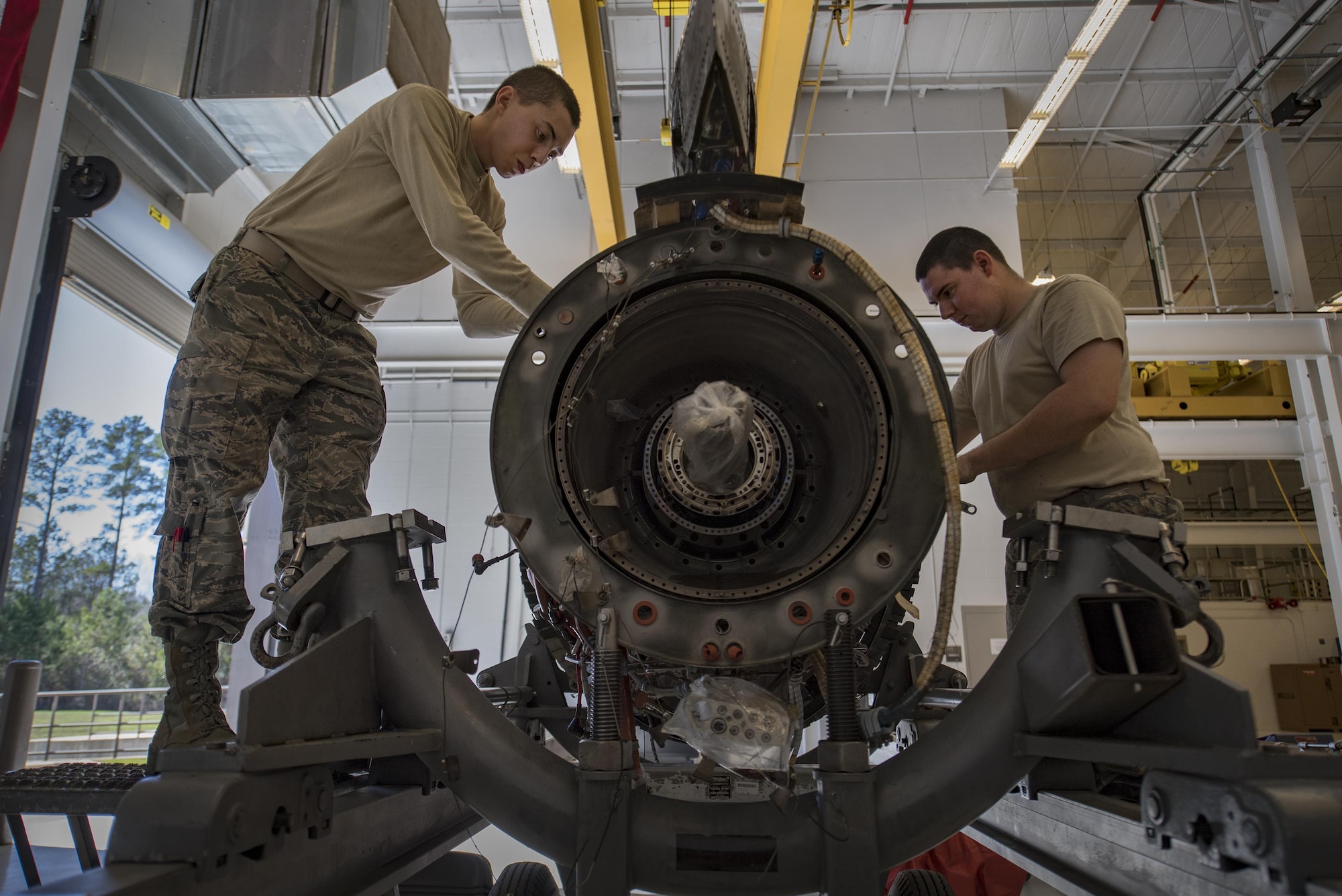 Both 23d Component Maintenance Squadron propulsion technicians, Airman 1st Class Anthony Guevara, left, and Airman 1st Class Jesse Mendheim, disassemble a TF-34 engine used in A-10C Thunderbolt lls, Jan. 25, 2017, at Moody Air Force Base, Ga. Airmen pay close attention to detail while systematically breaking the engine down. (U.S. Air Force photo by Airman 1st Class Daniel Snider)