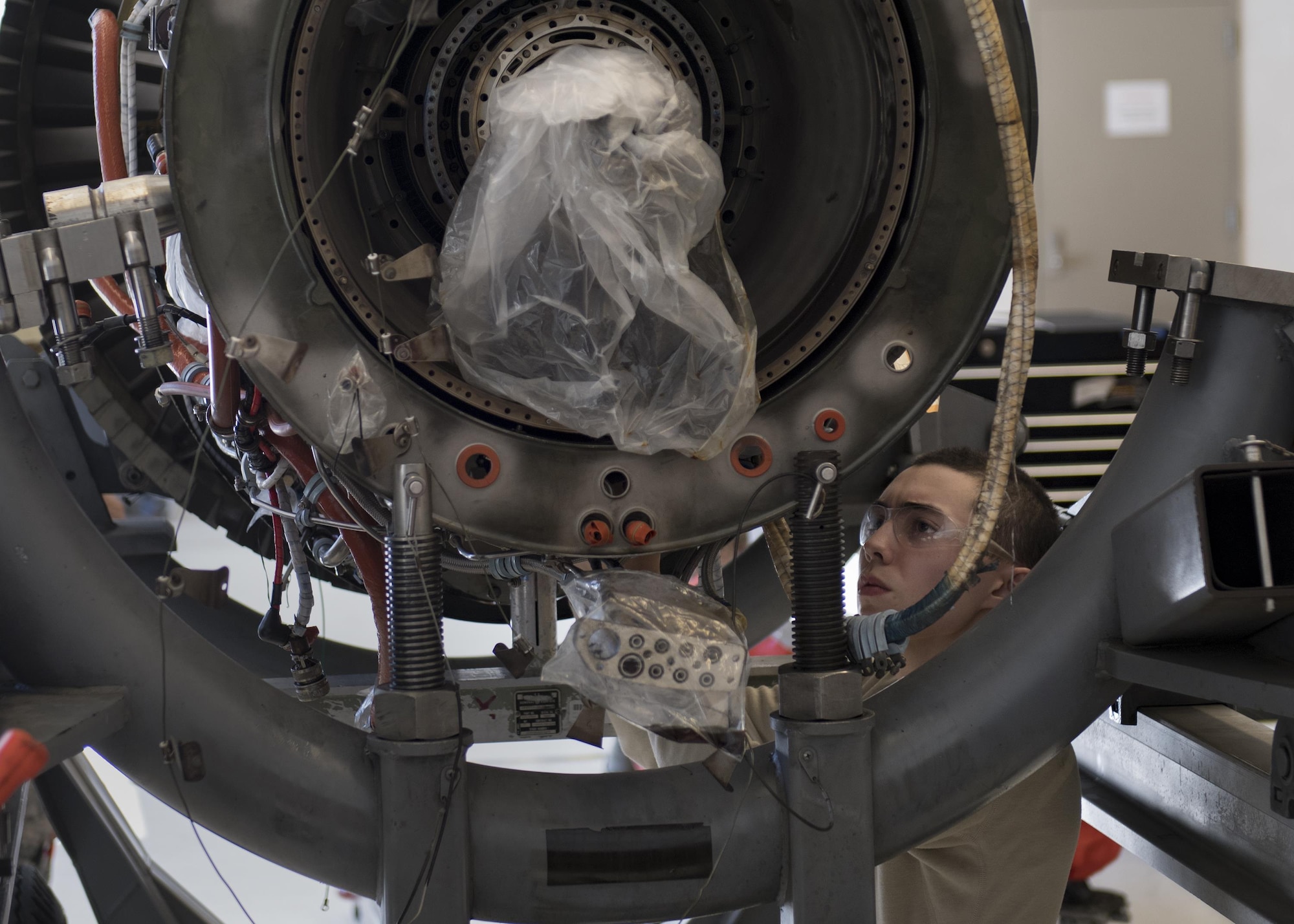 Airman 1st Class Anthony Guevara, 23d Component Maintenance Squadron propulsion technician, reaches into the underside of a TF-34 engine used in A-10C Thunderbolt lls, Jan. 25, 2017, at Moody Air Force Base, Ga. The 23d CMS is currently involved in an event aimed at decreasing the scheduled 28 days it takes to disassemble, repair and reassemble the TF-34 engine. (U.S. Air Force photo by Airman 1st Class Daniel Snider)
