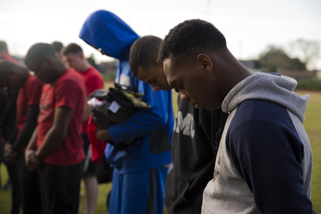 Marines from Marine Forces Reserve bow their heads for the chaplain’s prayer before commencing the Marine Corps Support Facility New Orleans Super Bowl tournament, Jan. 27, 2017. The tournament was held to build camaraderie, unit cohesion and esprit de corps between all departments within MARFORRES Headquarters. (U.S. Marine Corps photo by Lance Cpl. Dallas Johnson/Released)