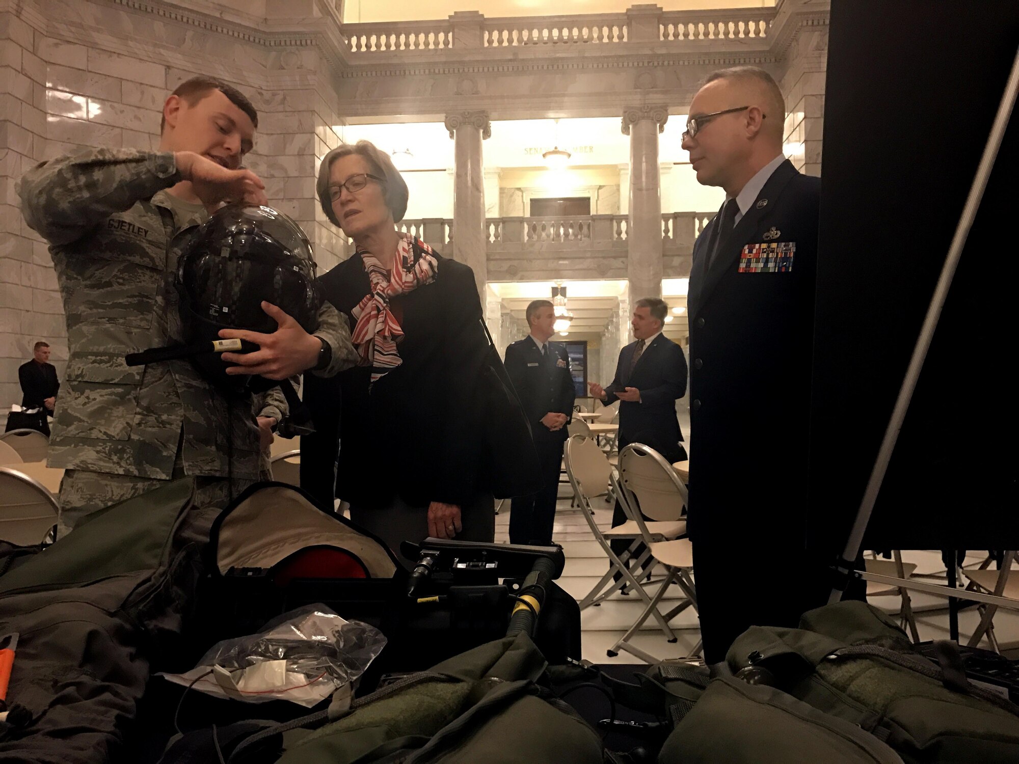 Staff Sgt Bruce Gjetley (left), 388th Operations Support Squadron, explains the finer points of the F-35A helmet to Utah State Senator Ann Millner and Chief Master Sgt. Don Stroud, 388th Fighter Wing command chief, June 26 at the Utah State Capitol Rotunda during the Utah Defense Alliance ‘Meet the Military’ event with the Utah legislature. (U.S. Air Force photo by Donovan Potter)