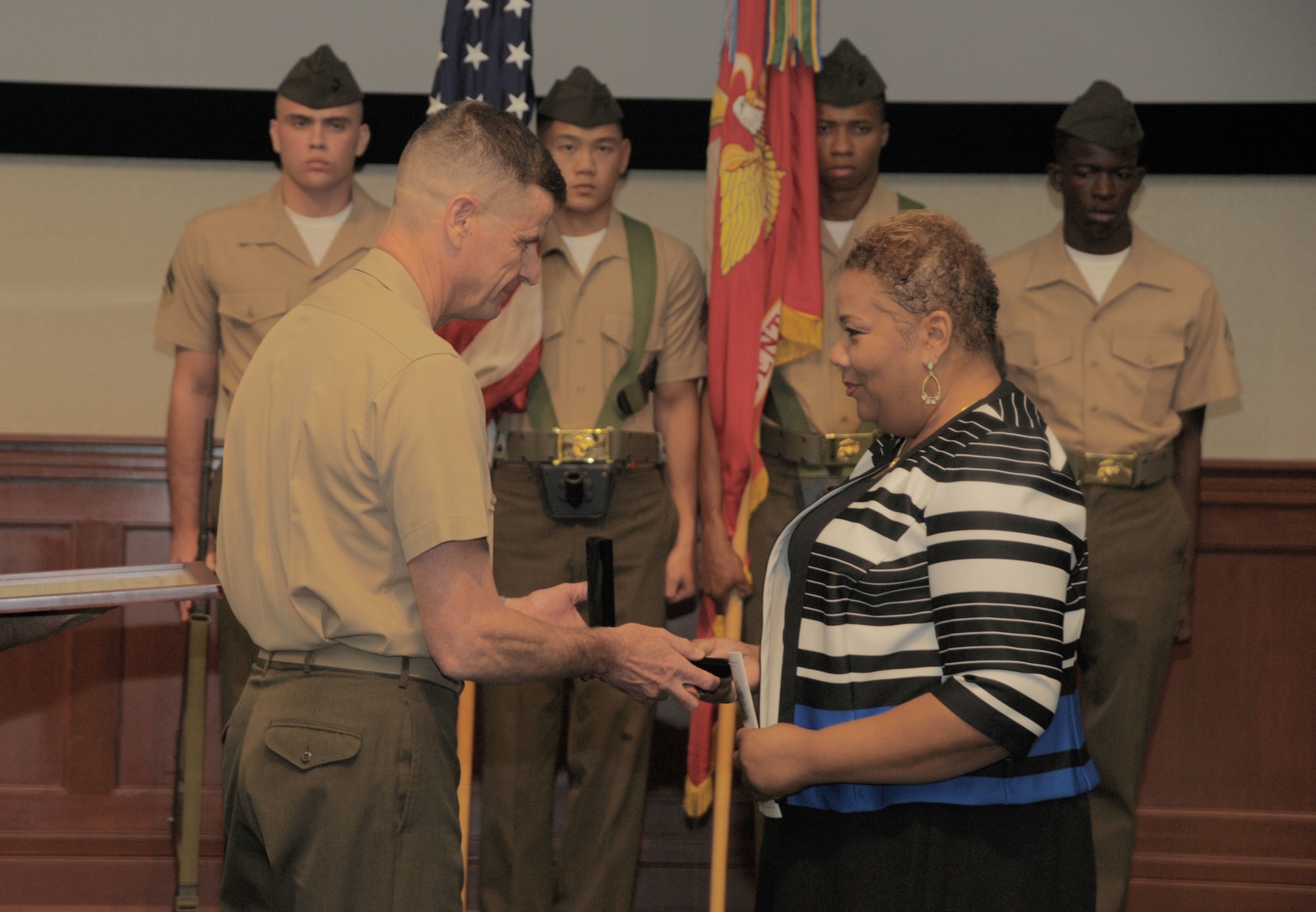 Kim Fountaine, right, accepts a posthumously awarded Congressional Gold Medal on behalf of her father, U.S. Marine Corps Pfc. Charles Robert Fountain, from Lt. Gen. William D. Beydler, commander of U.S. Marine Forces Central Command, at MacDill Air Force Base, Fla., Jan. 27, 2017. Fountain served during World War II and was a Montford Point Marine, a group of Marines who made history by volunteering to serve in a then segregated Marine Corps. (U.S. Air Force photo by Airman 1st Class Adam R. Shanks)
