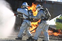 Cpl. Miguel Avalos and Lance Cpl. Brendan Bowles demonstrate proper techniques for putting out a fire during a live fire training event on Marine Corps Air Station New River, N.C., Jan. 19, 2017. While doing training, the Marines keep enough water with them for the training and for an emergency. Avalos and Bowles are rescuemen with Marine Corps Air Station New River’s Aircraft Rescue Firefighting division. (U.S. Marine Corps photo by Cpl. Melodie Snarr)