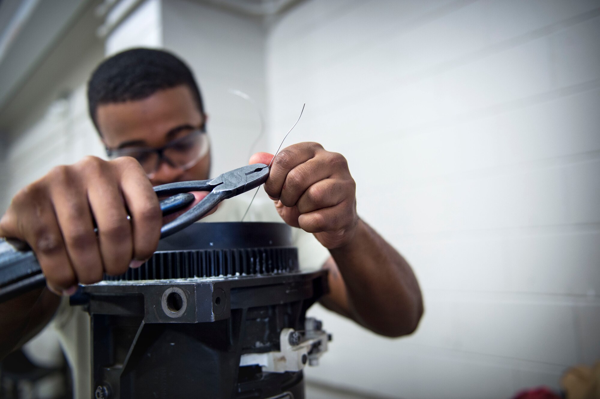 Staff Sgt. Disraeli Lee, an armament team chief with the 1st Special Operations Maintenance Squadron, installs a safety wire on a 25 mm Gatling gun at Hurlburt Field, Fla., Jan. 25, 2017. The safety wire ensures bolts are secured when firing the 25 mm Gatling gun. The Gatling gun can be found on the AC-130U Spooky gunship. (U.S. Air Force photo by Senior Airman Krystal M. Garrett)