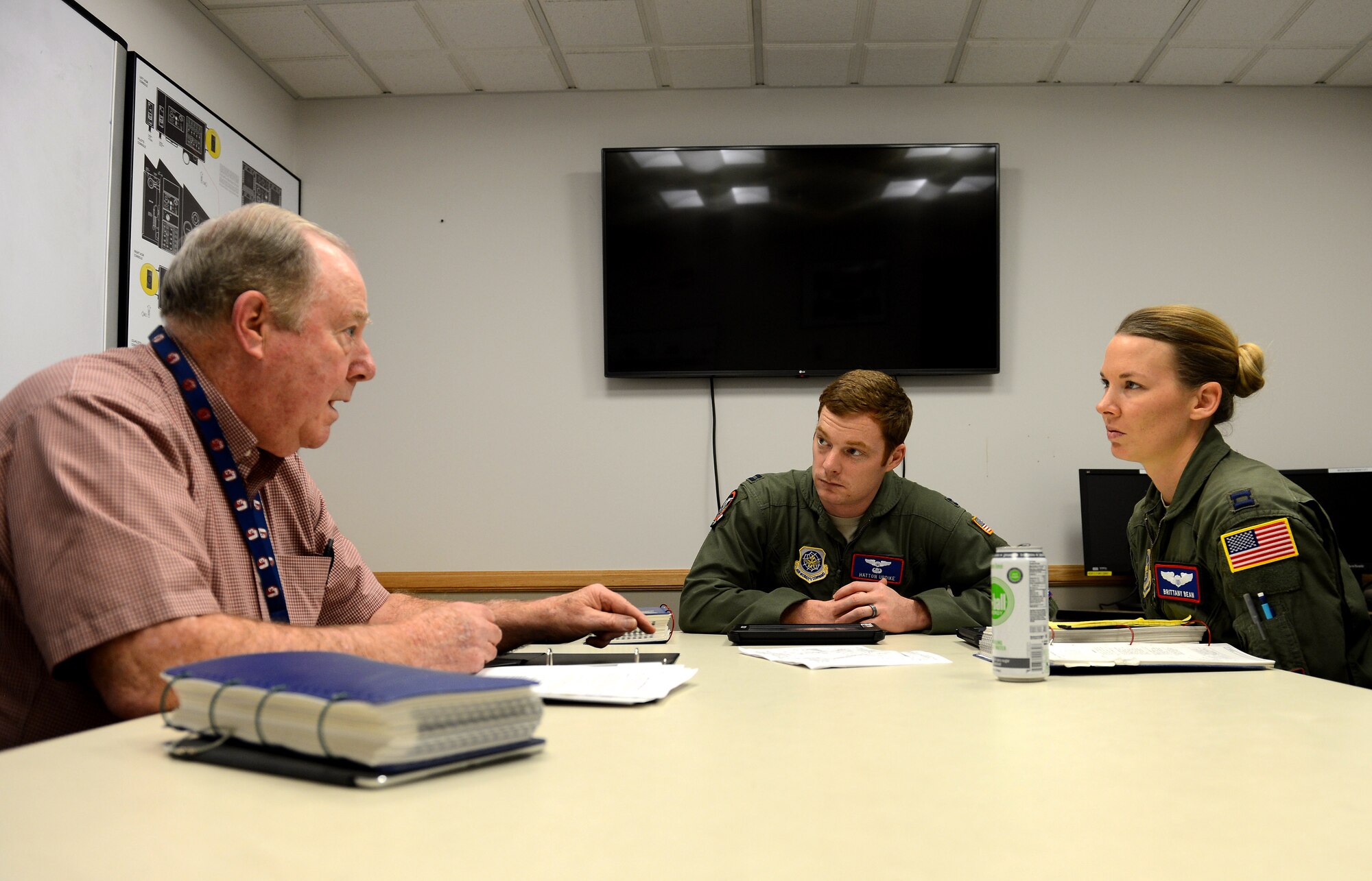 Capt. Brittany Bean (right)  and Capt. Hatton Updike (middle), both 4th Airlift Squadron C-17 Globemaster III pilots, receive a pre-training brief from Robert Callahan, C-17 instructor pilot, during a quarterly training session Jan. 26, 2017 at Joint Base Lewis-McChord, Wash. Before entering the simulator, pilots go through a pre-brief with a pilot instructor to prepare for their simulated mission. (U.S. Air Force photo/Senior Airman Divine Cox) 