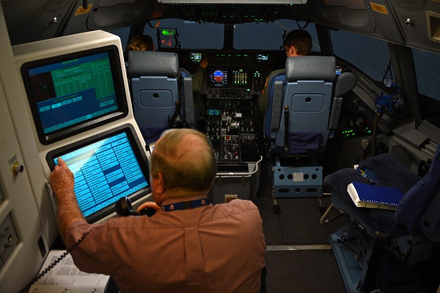 Robert Callahan, C-17 instructor pilot, observes Capt. Brittany Bean (left) and Capt. Hatton Updike (right), both 4th Airlift Squadron C-17 Globemaster III pilots, during a quarterly training session in a C-17 Globemaster III simulator Jan. 26, 2017 at Joint Base Lewis-McChord, Wash. Using the simulator gives pilots an opportunity to practice on things pilots can’t accomplish in the aircraft, but with a great level of realism. (U.S. Air Force photo/Senior Airman Divine Cox)
