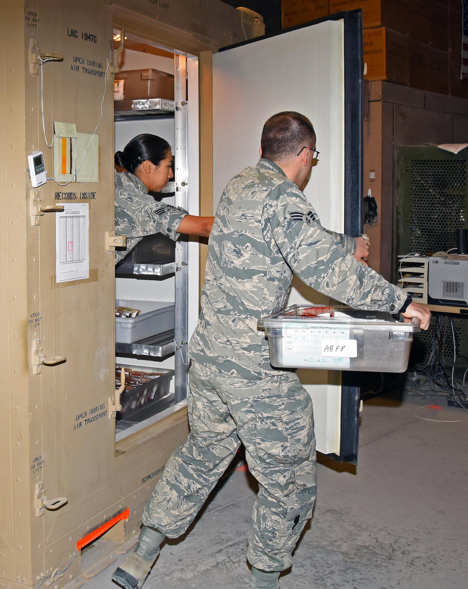 U.S. Air Force Senior Airman Celina Garcia, a medical logistics technician, left, and U.S. Air Force Senior Airman Dean Blackmore, a medical laboratory technician, both with the 379th Expeditionary Medical Group blood transshipment center, select blood units for shipment at Al Udeid Air Base, Qatar, Jan. 27, 2017. These Airmen operate primarily at night due to the strict temperature regulations in place to keep blood units viable. (U.S. Air Force photo by Senior Airman Cynthia A. Innocenti)