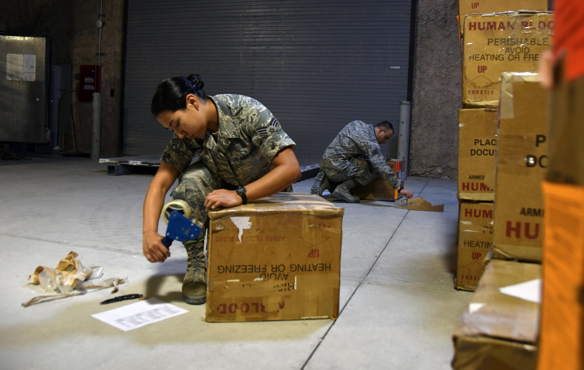 U.S. Air Force Senior Airman Celina Garcia, a medical logistics technician, left, and U.S. Air Force Senior Airman Dean Blackmore, a medical laboratory technician, both with the 379th Expeditionary Medical Group blood transshipment center, reinforce blood shipping containers at Al Udeid Air Base, Qatar, Jan. 27, 2017. These Airmen operate the only blood transshipment center for the entire Central Command area of responsibility. (U.S. Air Force photo by Senior Airman Cynthia A. Innocenti)