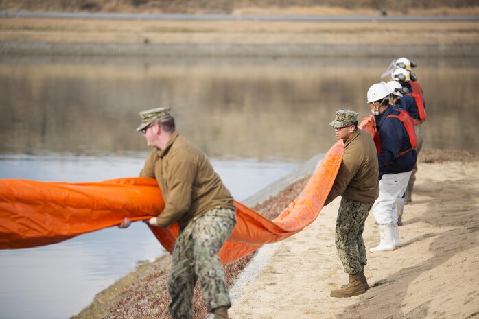 U.S. Sailors and facilities personnel respond to a simulated spill during a spill training exercise at Marine Corps Air Station Iwakuni, Japan, Jan. 27, 2017. The air station conducts an annual spill training exercise to evaluate response time, efficiency and to prepare for any spills that may occur. (U.S. Marine Corps photo by Lance Cpl. Joseph Abrego)