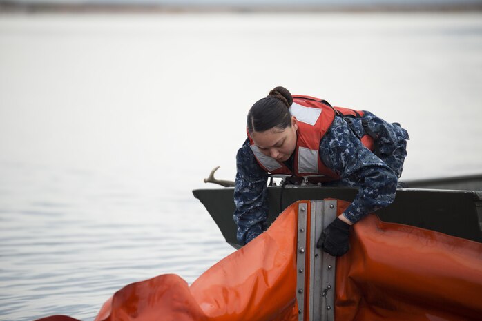 U.S. Navy Engineman 3rd Class, Yajaira Armenta Navarro, with harbor operations, ties a boom to a john boat during a spill training exercise at Marine Corps Air Station Iwakuni, Japan, Jan. 27, 2017. The boom is used during spills to corral oil and fuel into controlled areas. The air station conducts an annual spill training exercise to evaluate response time, efficiency and to prepare for any spills that may occur. (U.S. Marine Corps photo by Lance Cpl. Joseph Abrego)