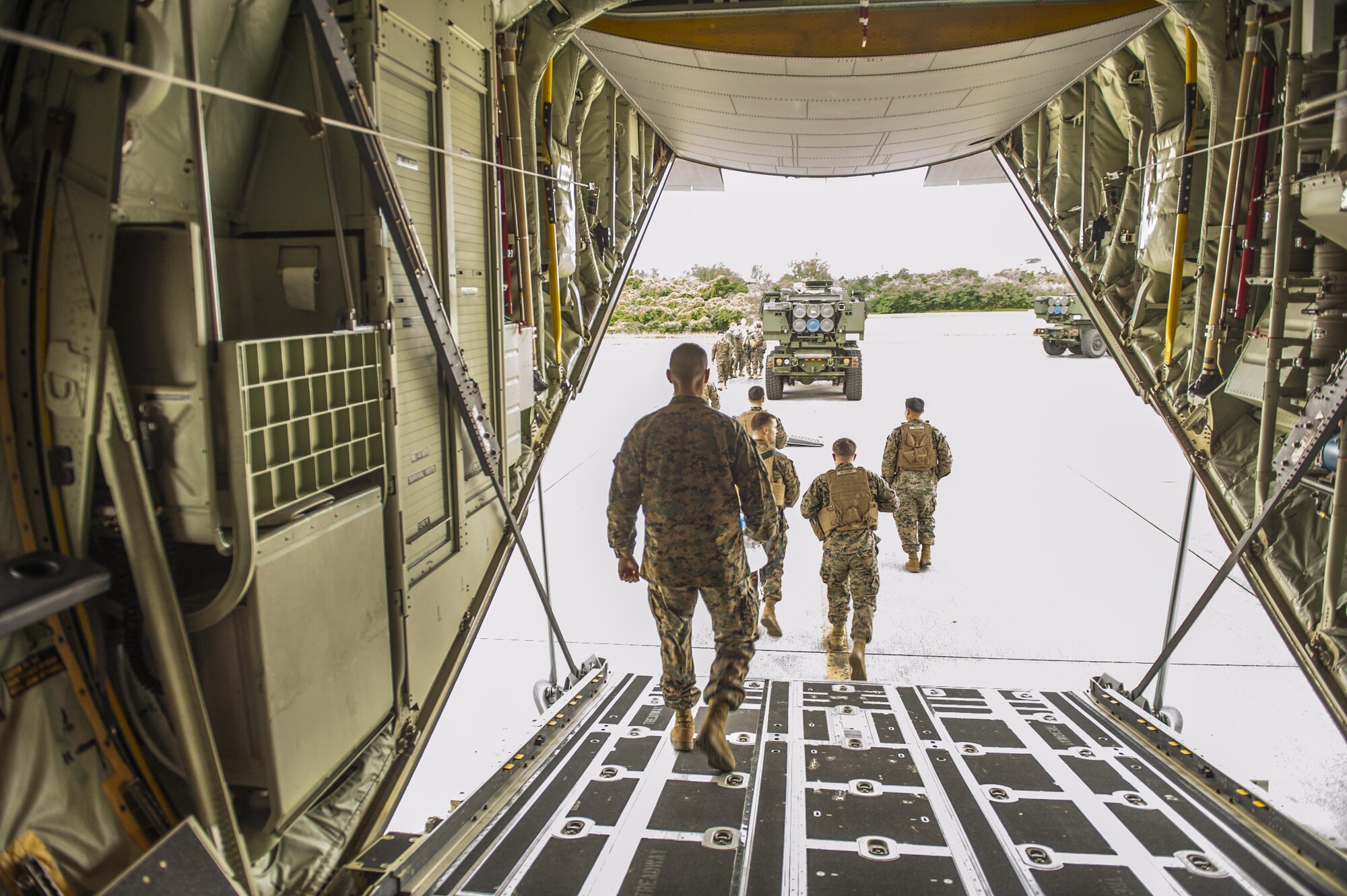 U.S. Marine Corps Marines with the 5th Battalion, 11th Marines, exit a C-130 Hercules after a briefing prior to training with 17th Special Operations Squadron Airmen on the flightline at Kadena Air Base, Japan, Jan. 23, 2017. Opportunities to train with members of other military branches allow for aircrew to learn about unfamiliar systems and types of operations. (U.S. Air Force photo by Airman 1st Class Nick Emerick/Released)