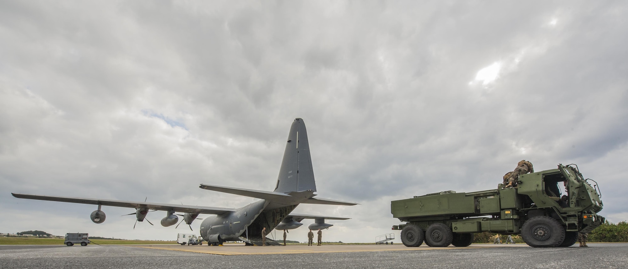 U.S. Marine Corps Marines with the 5th Battalion, 11th Marines, and U.S. Air Force Airmen with the 17th Special Operations Squadron, load a high mobility artillery rocket system onto a C-130 Hercules on the flightline at Kadena Air Base, Japan, Jan. 23, 2017. A HIMAR is a self-propelled artillery piece mounted on a 5-ton chassis with a rocket pod on the back that shoots rockets and missiles. (U.S. Air Force photo by Airman 1st Class Nick Emerick/Released)