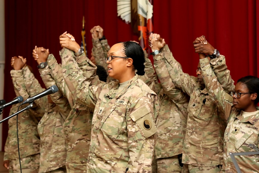 Soldiers hold hands after a quartet sing a medley in celebration of the life of Dr. Martin Luther King Jr. during an observance at Camp Arifjan, Kuwait, Jan. 12, 2016. The observance included the singing of the national anthem, a poem recital an a cappella quartet, and key note speakers.