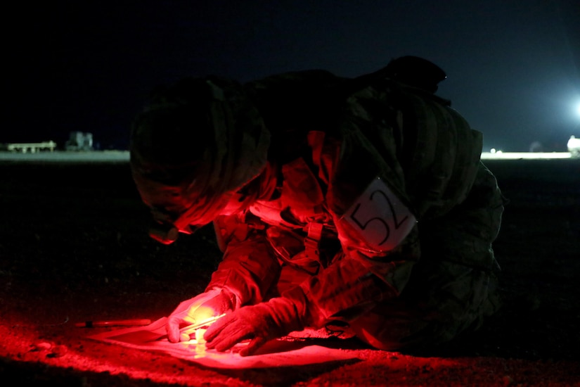 Sgt. Elizabeth Berry, a combat medic deployed to Kuwait, plots points during the land navigation portion of the Top Medic Competition, Dec. 18 at Camp Buehring, Kuwait. The stressful 36-hour competition, hosted by 3-1 AD, tested the Soldiers’ basic warrior skills, medical skills proficiency, and overall physical strength and endurance.