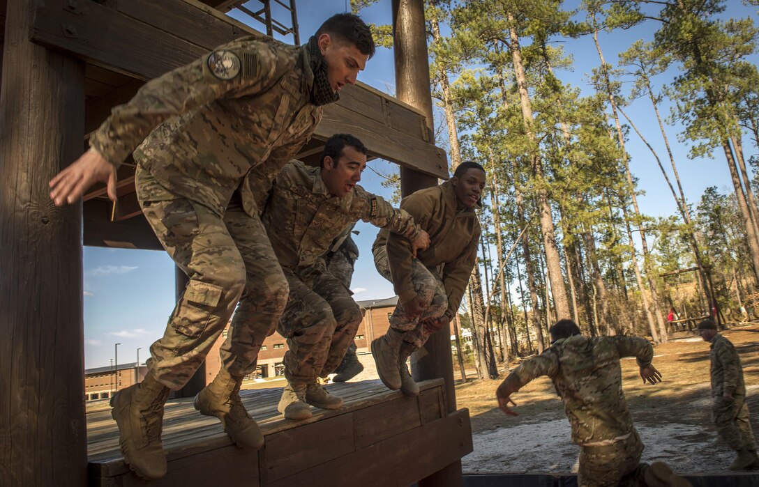 Airmen jump from a tower while navigating an obstacle course during Scorpion Lens at Fort Jackson, S.C., Jan. 29, 2017. Scorpion Lens is an annual training exercise for Air Force combat camera personnel. Air Force photo by Airman 1st Class James R. Crow