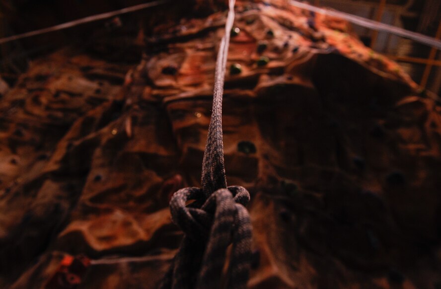 A rope is suspended over the top of a rock climbing wall at Ramstein’s Outdoor Recreation on Ramstein Air Base, Germany, Jan. 25, 2017. Participants in the Kaiserslautern Military Community’s ‘Biggest Loser’ challenge make a 10-week commitment to losing weight while working out and taking classes, such as rock climbing, that encourage the promotion of a healthy lifestyle. (U.S. Air Force photo by Airman 1st Class Savannah L. Waters)