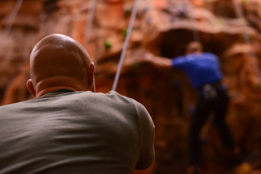 U.S. Air Force Staff Sgt. Zachary Bucher, 21st Operations Weather Squadron shift supervisor, pulls up U.S. Army Maj. Scott Whitworth, Landstuhl Regional Medical Center and Charlie Company radiologist, while rock climbing on Ramstein Air Base, Germany, Jan. 25, 2017. Rock climbing classes are being offered to active-duty members and Biggest Loser Challenge participants every Wednesday from 1700 to 1900. (U.S. Air Force photo by Airman 1st Class Savannah L. Waters) 