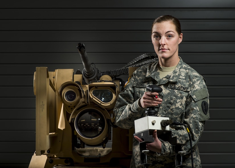 Spc. Rachel Schulte, a U.S. Army Reserve Soldier with the 354th Military Police Company, of St. Louis, Missouri, poses with a Common Remotely Operated Weapon Station (CROWS), at Fort Chaffee, Arkansas, Jan. 26. The CROWS is a remote-controlled system compatible with four major crew-serve weapons, and it was developed to keep gunners safe within the vehicle while engaging enemy targets. (U.S. Army Reserve photo by Master Sgt. Michel Sauret)