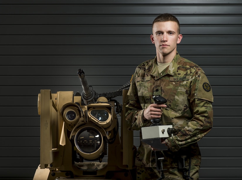 Spc. Ethan Moe, a U.S. Army Reserve Soldier with the 800th Military Police Company, of Little Rock, Arkansas, poses with the Common Remotely Operated Weapon Station (CROWS), at Fort Chaffee, Arkansas, Jan. 26. The CROWS is a remote-controlled system compatible with four major crew-serve weapons, and it was developed to keep gunners safe within the vehicle while engaging enemy targets. (U.S. Army Reserve photo by Master Sgt. Michel Sauret)