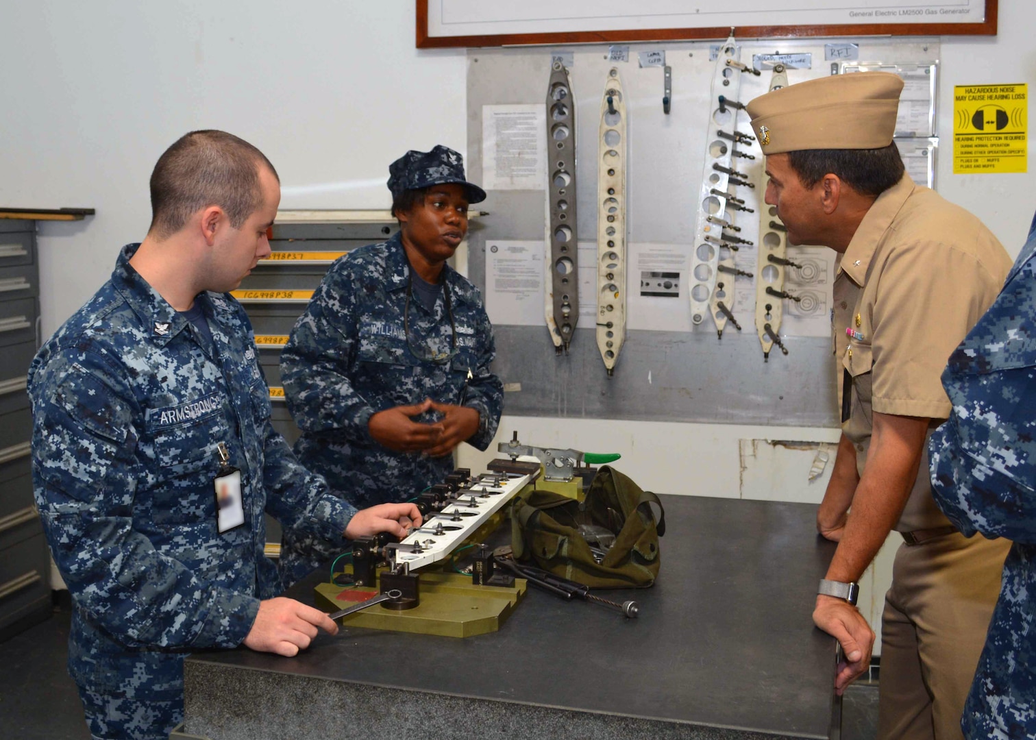 Gas Turbine Systems Technician (Maintenance) 2nd Class Matthew Armstrong and Gas Turbine Systems Technician (Maintenance) Carla Williams explain how they perform maintenance on replacement parts for ship repairs to Rear Admiral Stephen F. Williamson.  Rear Adm. Williamson was onboard to engage key staff on ship maintenance and workload. 