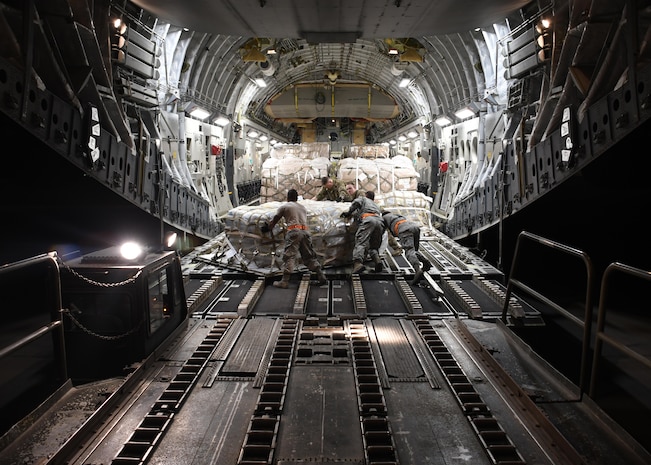 U.S. Air Force Airmen from the 8th Expeditionary Air Mobility Squadron and 816th Expeditionary Airlift Squadron load cargo onto a C-17 Globemaster III at Al Udeid Air Base, Qatar, Dec. 23, 2016. After loading the cargo, the two squadrons secure it so there are no issues while in flight. In 2016, the 816th EAS flew more than 2,400 missions, moving nearly 102,000 tons of cargo and almost 120,000 passengers. (U.S. Air Force photo by Senior Airman Miles Wilson)