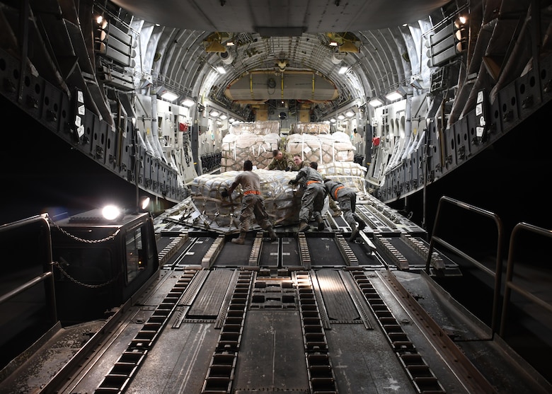 U.S. Air Force Airmen from the 8th Expeditionary Air Mobility Squadron and 816th Expeditionary Airlift Squadron load cargo onto a C-17 Globemaster III at Al Udeid Air Base, Qatar, Dec. 23, 2016. After loading the cargo, the two squadrons secure it so there are no issues while in flight. In 2016, the 816th EAS flew more than 2,400 missions, moving nearly 102,000 tons of cargo and almost 120,000 passengers. (U.S. Air Force photo by Senior Airman Miles Wilson)