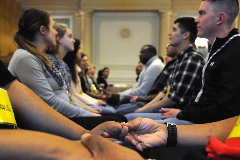 Couples hold hands during an exercise Jan. 27 as part of a 99th Regional Support Command Strong Bonds event in Baltimore, Maryland.  Strong Bonds is a unit-based, chaplain-led program which assists commanders in building individual resiliency by strengthening the Army Family. The core mission of the Strong Bonds program is to increase individual Soldier and Family member readiness through relationship education and skills training.