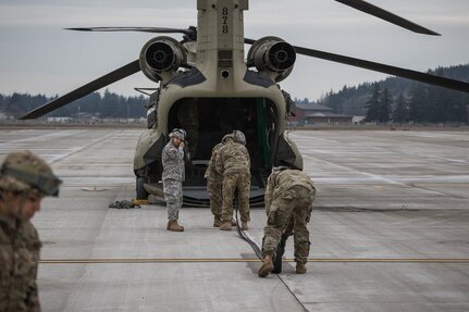 U.S. Army Soldiers assigned to 16th Combat Aviation Brigade, 7th Infantry Division roll hoses out of a U.S. Army Reserve CH-47 Chinook helicopter during training at Joint Base Lewis-McChord, Wash., Jan. 26, 2017. The Soldiers used the Forward Area Refueling Equipment to refuel Uh-60 Black Hawk helicopters in order to increase their proficiency before their upcoming mission in Afghanistan. 
