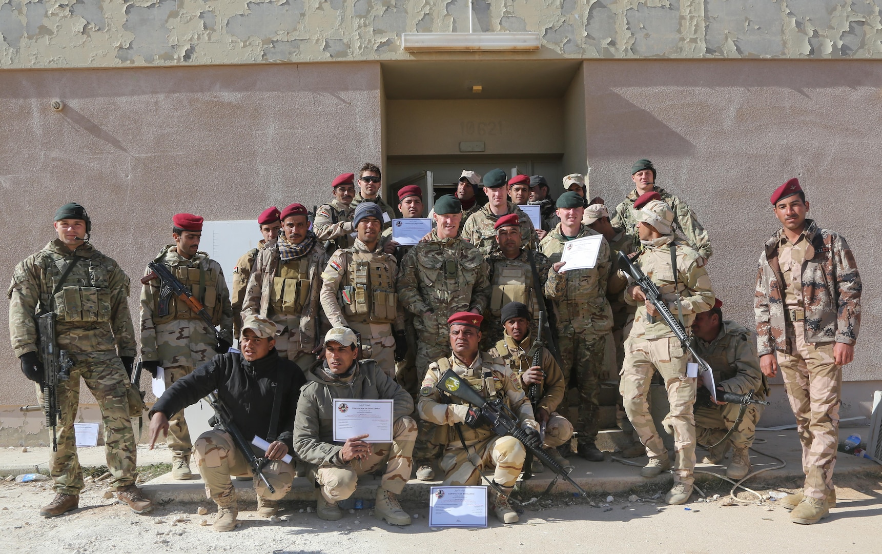 Iraqi soldiers from 7th Iraqi Army Division, British trainers from 4th Battalion, "The Rifles", and Danish trainers show off graduation certificates after the culminating exercise at Al Asad Air Base, Iraq, Jan. 15, 2017. Training at building partner capacity sites is an integral part of Combined Joint Task Force – Operation Inherent Resolve’s effort to train Iraqi security forces personnel. CJTF-OIR is the global Coalition to defeat ISIL in Iraq and Syria. (U.S. Army photo by Sgt. Lisa Soy)