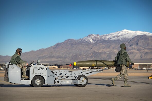 Airman First Class Connor McDonald, left, and Staff Sgt. Tayrell Washington, both 74th Aircraft Maintenance Unit weapons load team members, use an MJ-1C bomb lift to transport a Mark 82 general purpose bomb during Green Flag-West 17-03, Jan. 24, 2017, at Nellis Air Force Base, Nev. Weapons Airmen enabled joint force training during the two-week exercise by loading weapons, inspecting jets and maintaining munitions systems. Some of the live munitions included the Mark 82 and 84 general purpose bombs, high-explosive incendiary 30mm rounds and the 500 pound GBU-12 Paveway II laser-guided bomb. (U.S. Air Force photo by Staff Sgt. Ryan Callaghan)