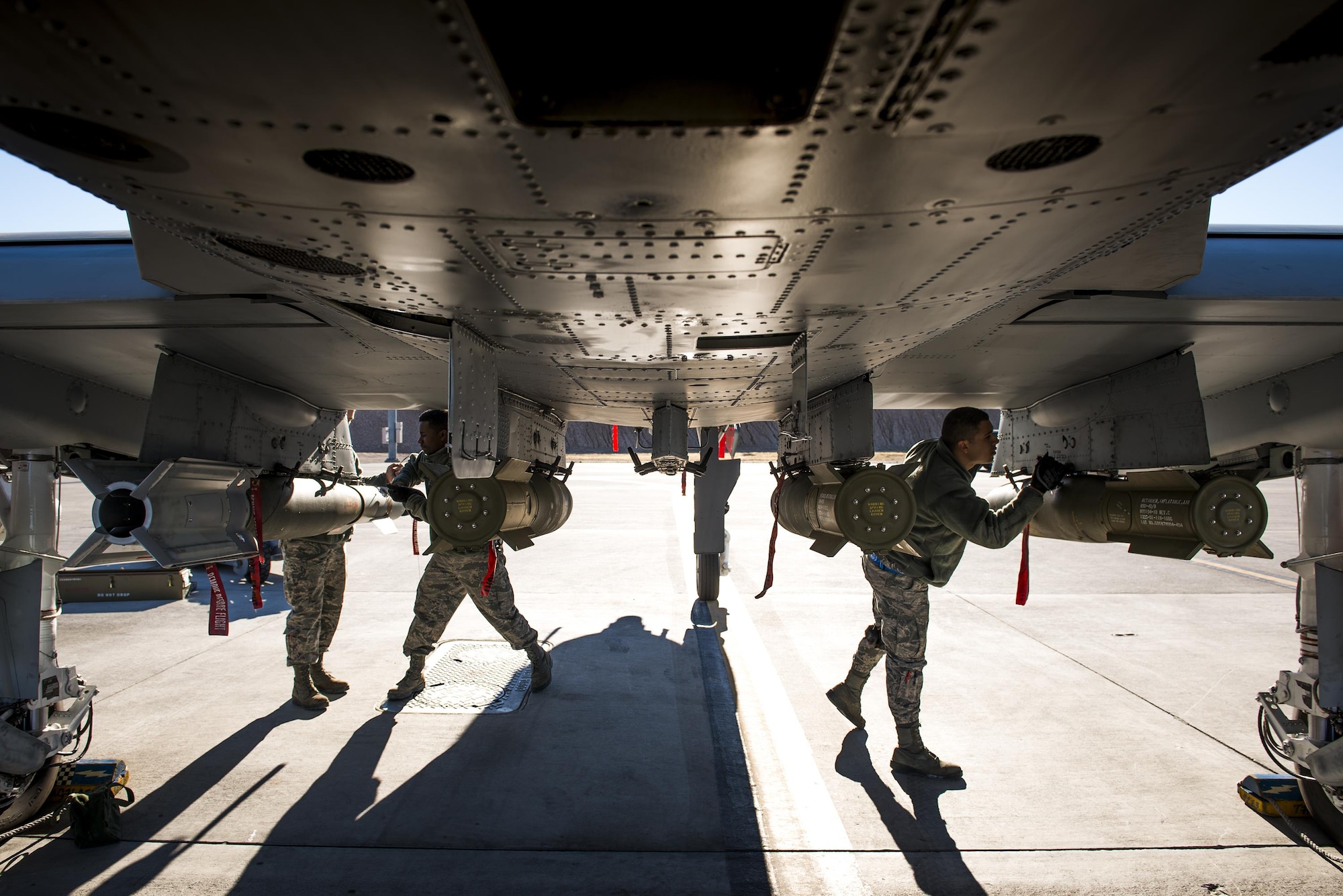 A weapons load team conducts final checks on munitions underneath an A-10C Thunderbolt II during Green Flag-West 17-03, Jan. 24, 2017, at Nellis Air Force Base, Nev. Weapons Airmen enabled joint force training during the two-week exercise by loading weapons, inspecting jets and maintaining munitions systems. Some of the live munitions included the Mark 82 and 84 general purpose bombs, high-explosive incendiary 30mm rounds and the 500 pound GBU-12 Paveway II laser-guided bomb. (U.S. Air Force photo by Staff Sgt. Ryan Callaghan)