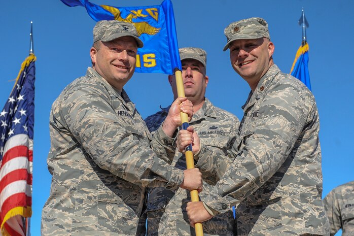Col. Shane Henderson, 57th Maintenance Group commander, and Maj. Matthew Zakri, 57th Munitions Squadron commander, pose with the 57th MUNS guidon during a redesignation ceremony at Nellis Air Force Base, Nev., Jan. 27, 2017. Zakri relinquished command of the 57th Maintenance Squadron, Henderson officiated its inactivation, and then Zakri assumed command of the 57th MUNS -- which was formerly known as the 57th Munitions Maintenance Squadron.