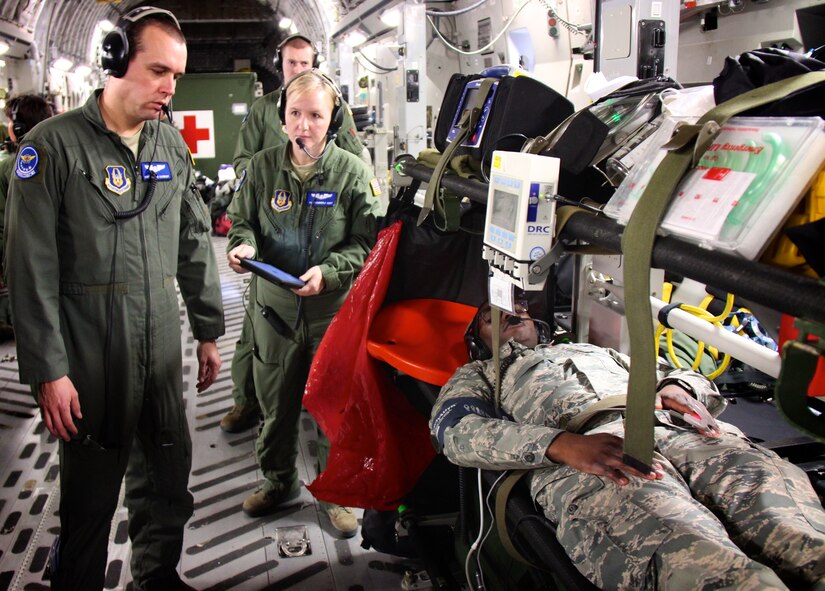 Left to right:  Master Sgt. Joshua Barnaby and Tech Sgt. Kimberly Hurt, 932nd Aeromedical Evacuation Squadron medical technicians, move to take care of their simulated patient in the air aboard a C-17.  They flew training flights with the 514th Air Mobility Wing from March 27-29.  (U.S. Air Force photo by Lt. Col. Stan Paregien)