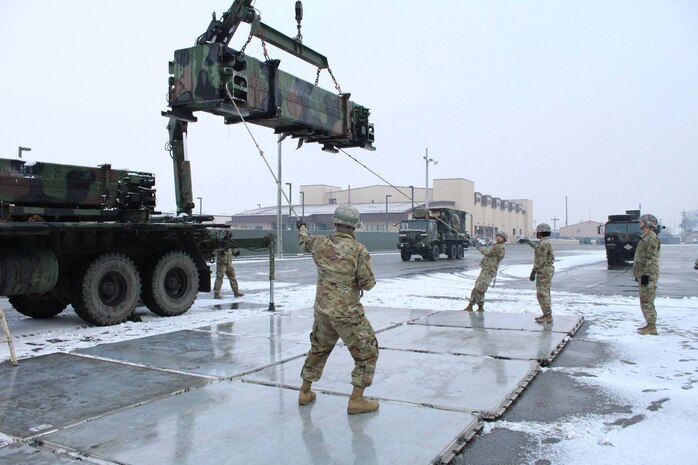 Soldiers assigned to 6-52 Air Defense Artillery Brigade conduct joint air load training with the 51st Logistics Readiness Squadron at Osan Air Base, Republic of Korea, Jan. 12, 2017. The Soldiers are offloading a Patriot missile canister to prepare it for aerial transportation on a 463L pallet. 