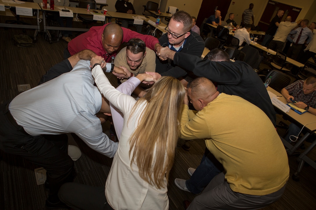 Senior leaders from across Marine Forces Reserve use teamwork to work on untangling themselves from a human knot while participating in an exercise during the Senior Leadership Workshop at Marine Corps Support Facility New Orleans, Jan. 23-26, 2017. The Marines and Sailors participated in multiple exercises and discussions that address differences in leadership styles, perspectives, experiences, backgrounds and more. The workshop aims to emphasize the importance of open communication and equal opportunity, and to demonstrate their effects on unit cohesion, mission accomplishment and mission readiness. (U.S. Marine Corps photo by Sgt. Sara Graham) 