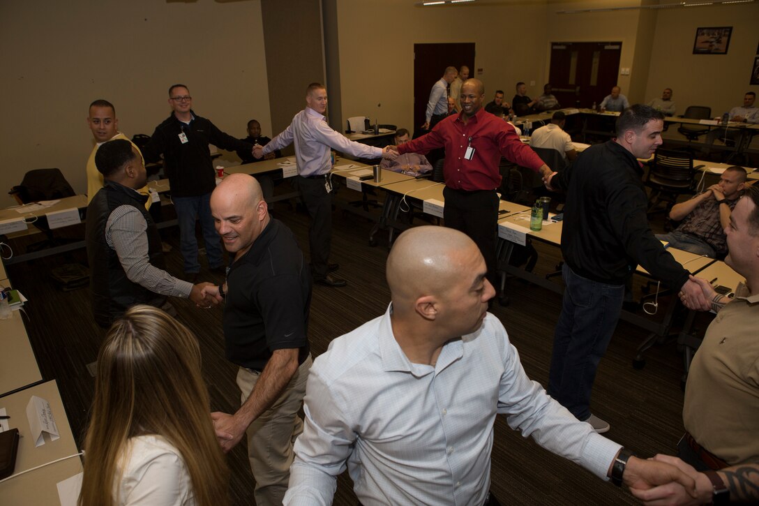 Senior leaders from across Marine Forces Reserve successfully untangle themselves from a human knot while participating in an exercise at Senior Leadership Workshop aboard Marine Corps Support Facility New Orleans, Jan. 23-26, 2017. The Marines and Sailors participated in multiple exercises and discussions that address differences in leadership styles, perspectives, experiences, backgrounds and more. The workshop aims to emphasize the importance of open communication and equal opportunity, and to demonstrate their effects on unit cohesion, mission accomplishment and mission readiness.  (U.S. Marine Corps photo by Sgt. Sara Graham) 