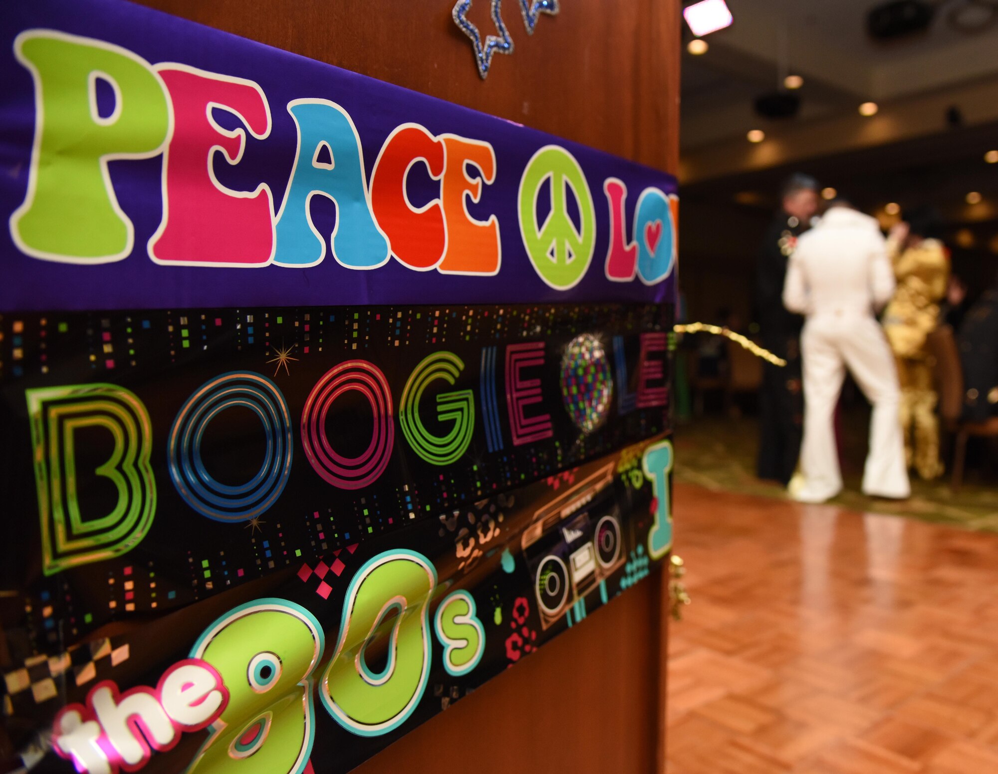 Blast From The Past themed banners hang on a podium at the 29th Annual Krewe of Medics Mardi Gras Ball at the Bay Breeze Event Center Jan. 28, 2017, on Keesler Air Force Base, Miss. The Krewe of Medics hosts a yearly ball to give Keesler Medical Center personnel a taste of the Gulf Coast and an opportunity to experience a traditional Mardi Gras. (U.S. Air Force photo by Kemberly Groue)