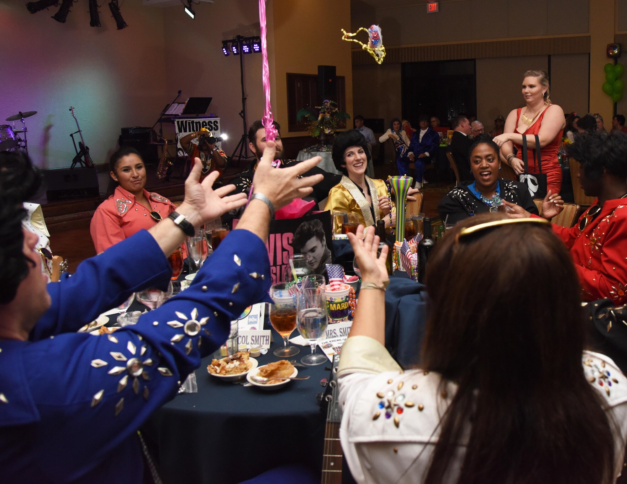 Col. C. Mike Smith, 81st Training Wing vice commander, and his wife, Kristi, reach for beads during the 29th Annual Krewe of Medics Mardi Gras Ball at the Bay Breeze Event Center Jan. 28, 2017, on Keesler Air Force Base, Miss. The Krewe of Medics hosts a yearly ball to give Keesler Medical Center personnel a taste of the Gulf Coast and an opportunity to experience a traditional Mardi Gras. The theme for this year's ball was Blast From The Past. (U.S. Air Force photo by Kemberly Groue)