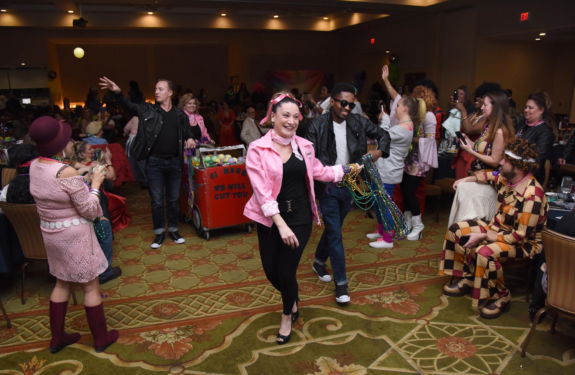 Senior Airman Natalie Malloy, 81st Inpatient Operations Squadron medical technician, and Staff Sgt. Quaci Allen, 81st Surgical Operations Squadron medical technician, dance down the aisle during a Mardi Gras float contest during the 29th Annual Krewe of Medics Mardi Gras Ball at the Bay Breeze Event Center Jan. 28, 2017, on Keesler Air Force Base, Miss. The Krewe of Medics hosts a yearly ball to give Keesler Medical Center personnel a taste of the Gulf Coast and an opportunity to experience a traditional Mardi Gras. The theme for this year's ball was Blast From The Past. (U.S. Air Force photo by Kemberly Groue)