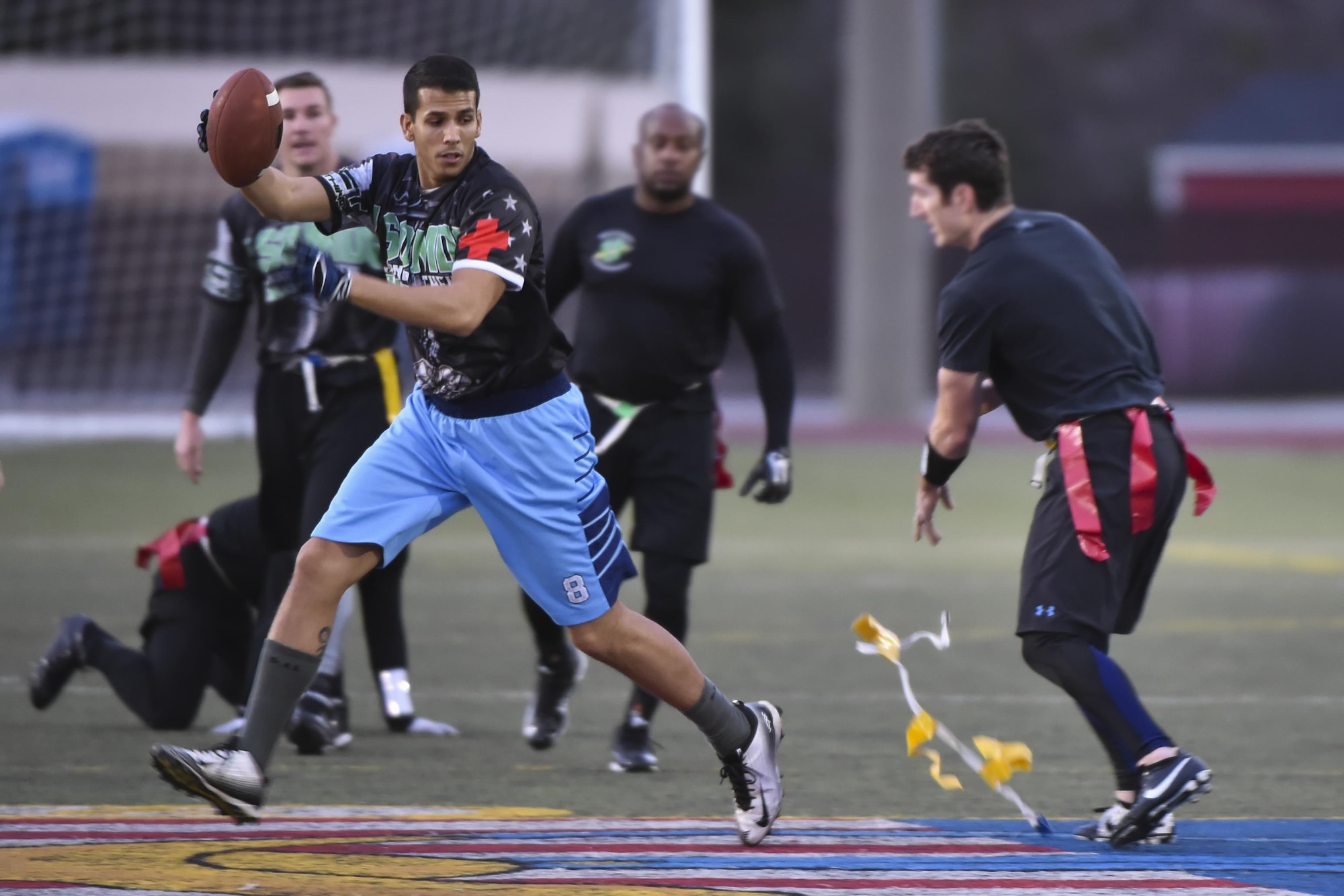 A defensive player for the 23rd Special Tactics Training Squadron intramural flag football team pulls the flag of Miguel De Castro, the center for the 1st Special Operations Medical Group team, during the flag football championship at Hurlburt Field, Fla., Jan. 26, 2017. The 1st SOMDG defeated the 23rd STTS by the score of seven to six. (U.S. Air Force photo by Airman 1st Class Joseph Pick)