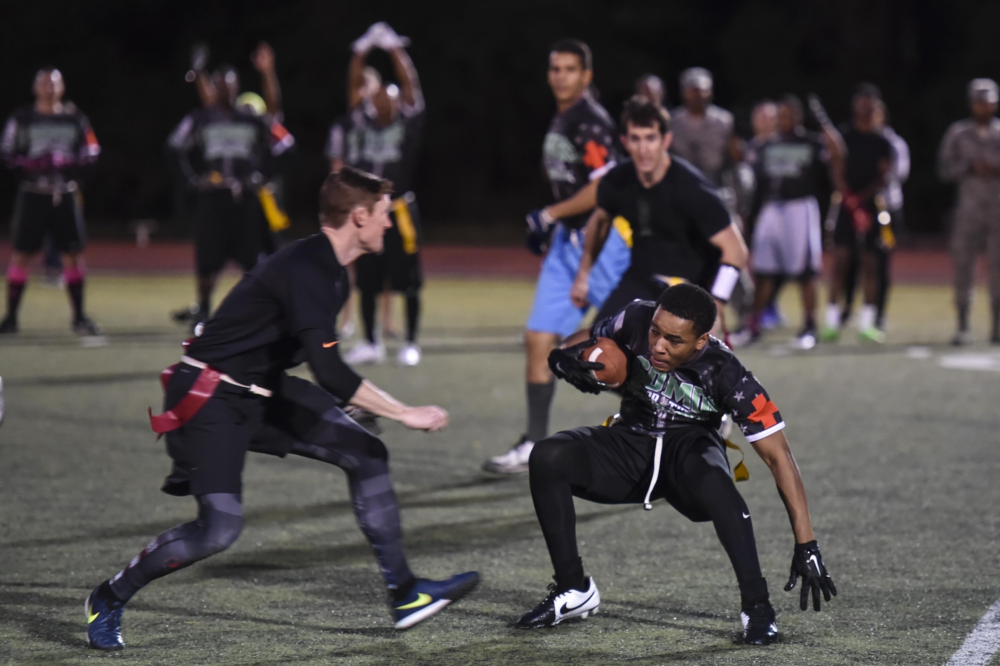 Emmanuel Parker, a receiver for the 1st Special Operations Medical Group intramural flag football team, zig zags by a defensive player for the 23rd Special Tactics Training Squadron team during the flag football championship at Hurlburt Field, Fla., Jan. 26, 2017. More than 24 teams competed in approximately 74 games during the season. (U.S. Air Force photo by Airman 1st Class Joseph Pick)