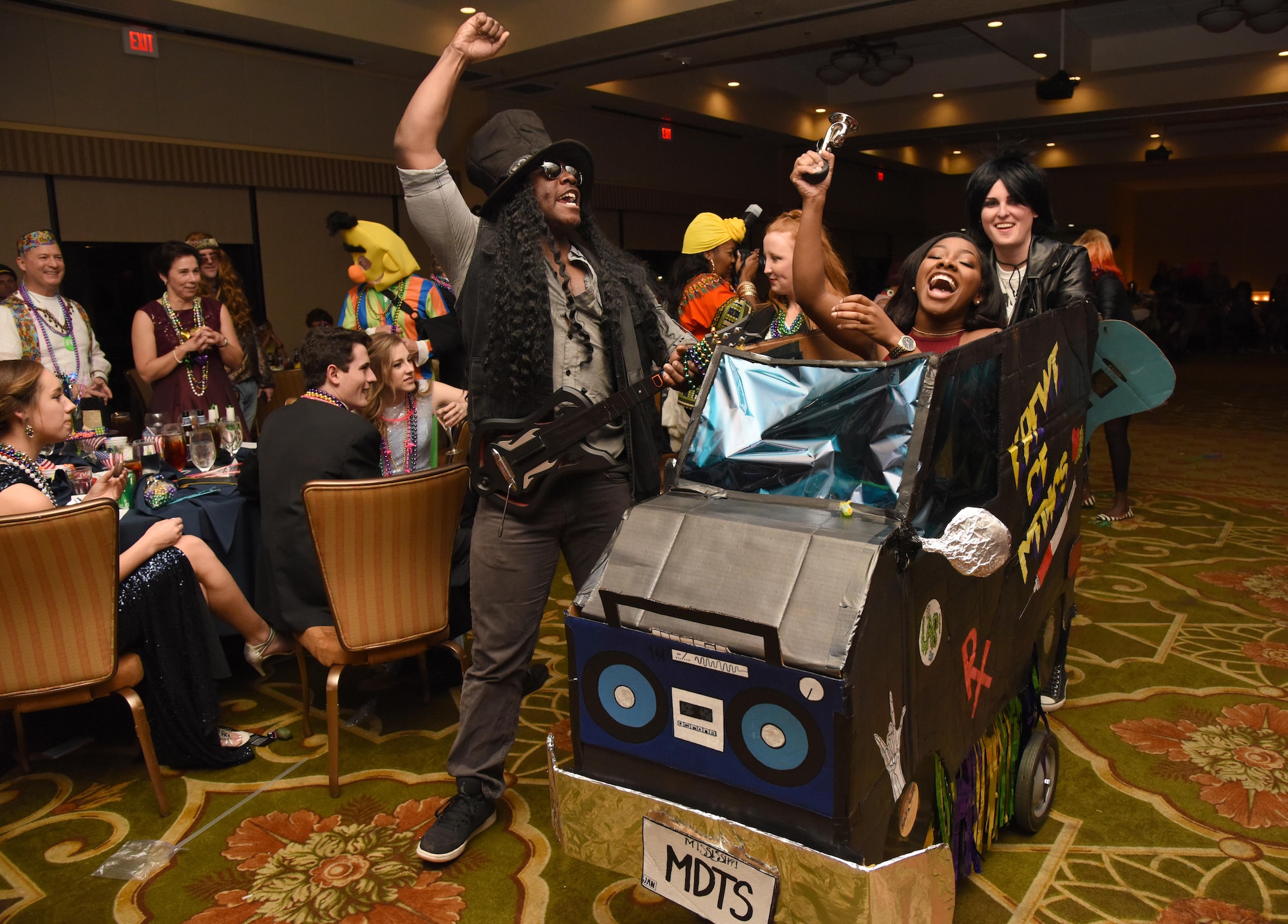 Members of the 81st Diagnostic and Therapeutics Squadron make their way down the aisle during a Mardi Gras float contest at the 29th Annual Krewe of Medics Mardi Gras Ball at the Bay Breeze Event Center Jan. 28, 2017, on Keesler Air Force Base, Miss. The Krewe of Medics hosts a yearly ball to give Keesler Medical Center personnel a taste of the Gulf Coast and an opportunity to experience a traditional Mardi Gras. The theme for this year's ball was Blast From The Past. (U.S. Air Force photo by Kemberly Groue)